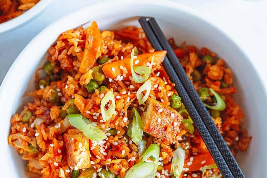 A bowl of Easy Vegan Kimchi Fried Rice With Tofu And Peas