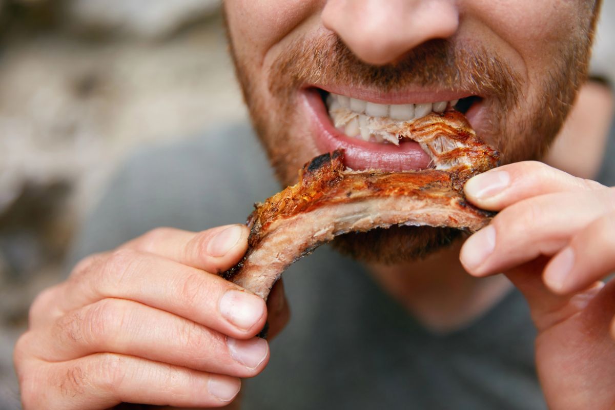 Mans mouth eating ribs