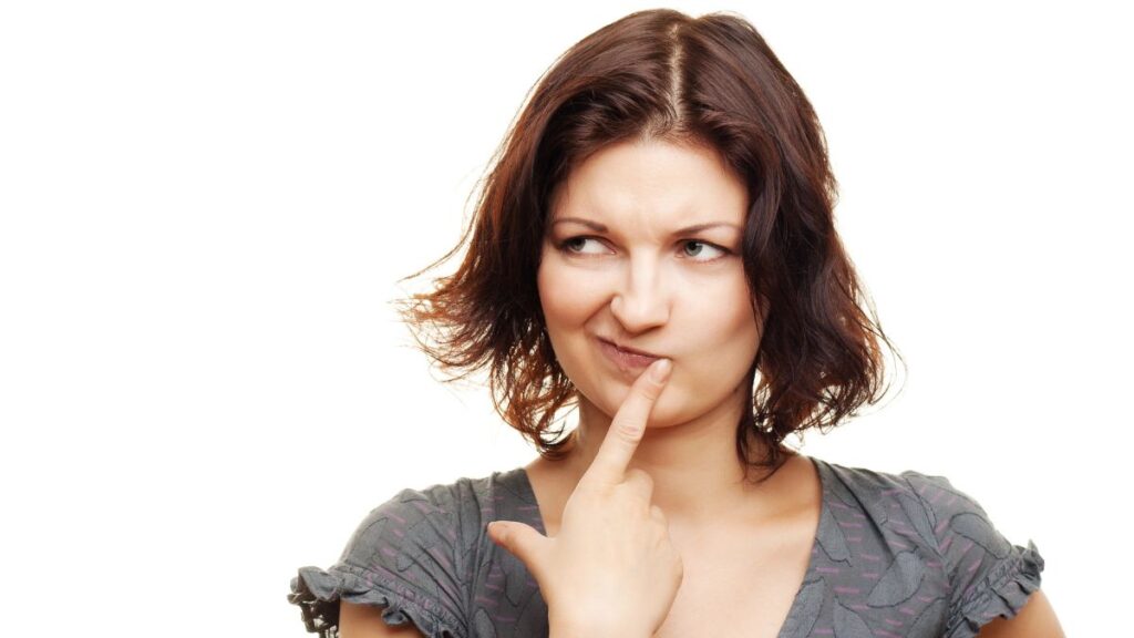 confused looking woman with hand on chin looking up