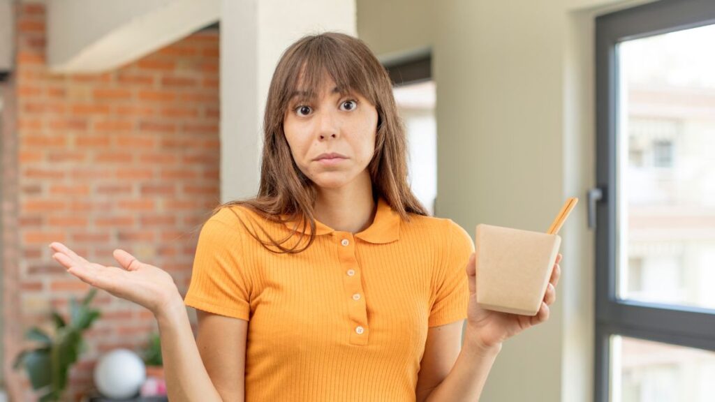 confused woman holding food container