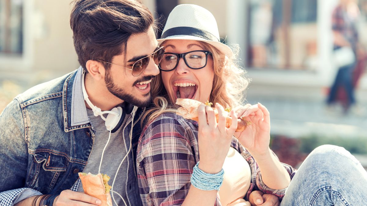 couple enjoying sandwich outside