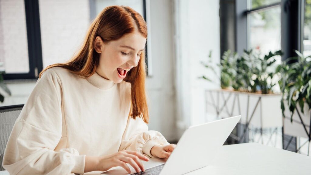 excited woman typing at computer