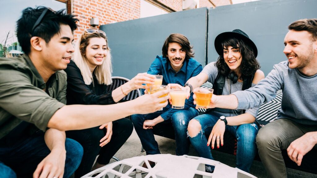 friends doing cheers drinking outside