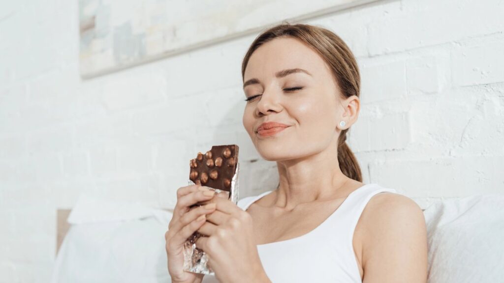 happy woman sitting and eating chocolate