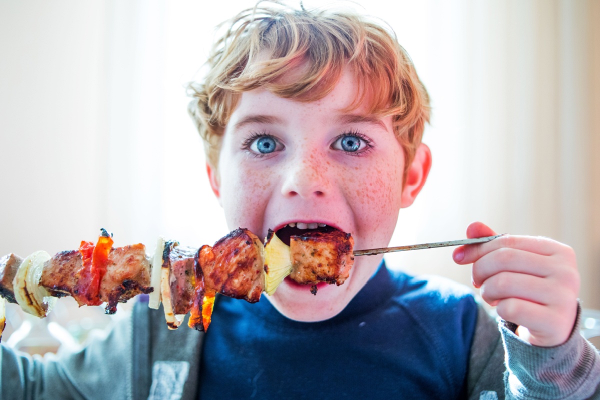 kid eating chicken skewer BBQ