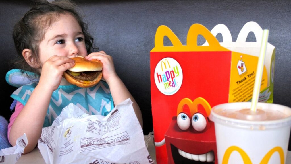 little girl eating a happy meal