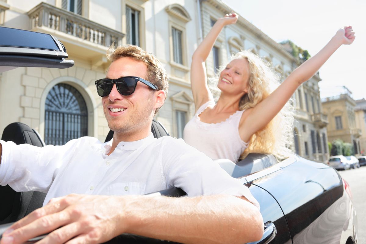 man and woman in a convertible