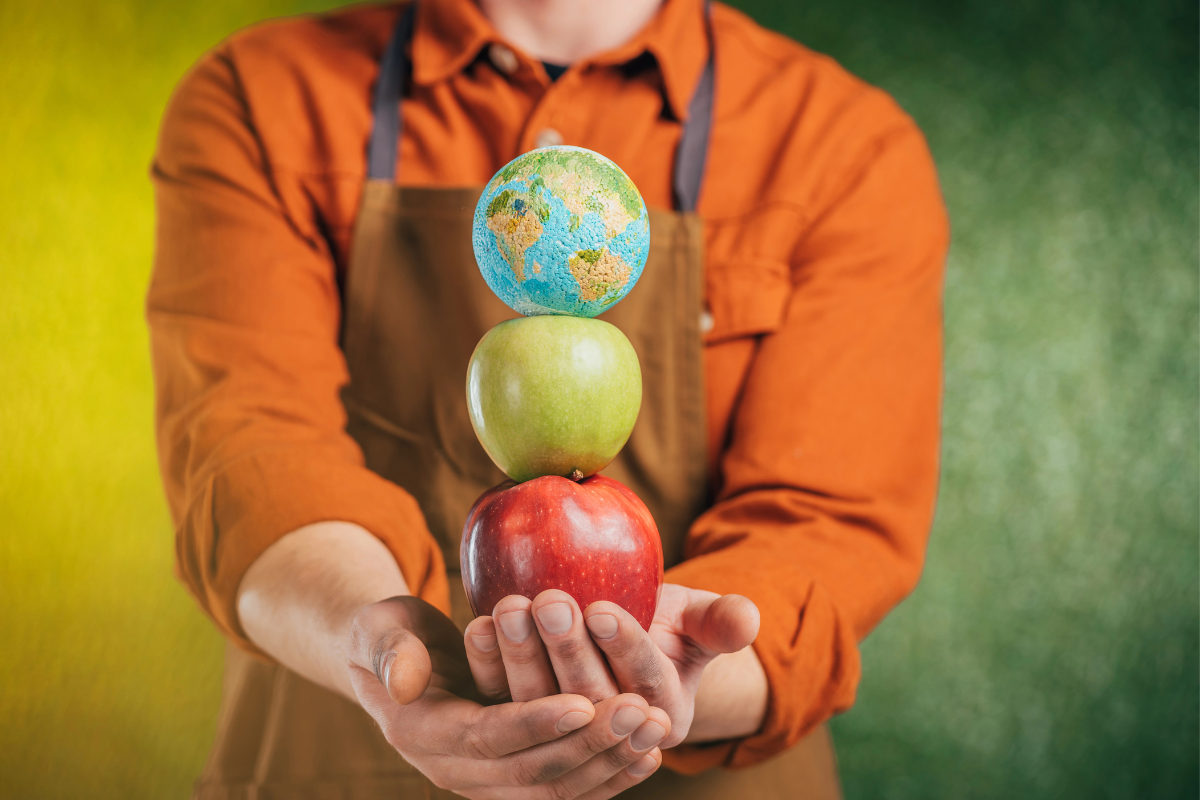 man holding apples and a small globe