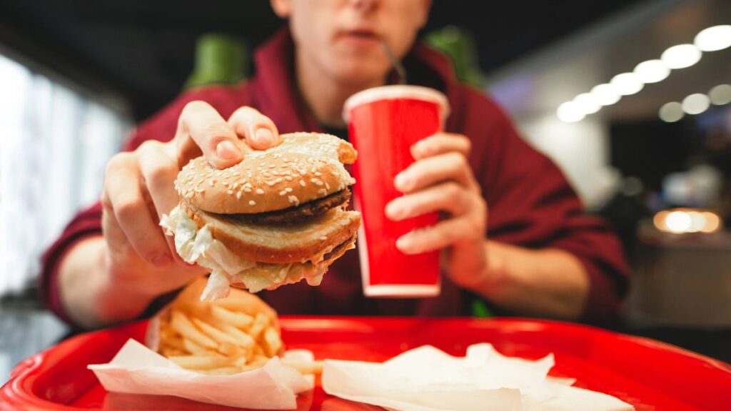 man with fast food burger and soda