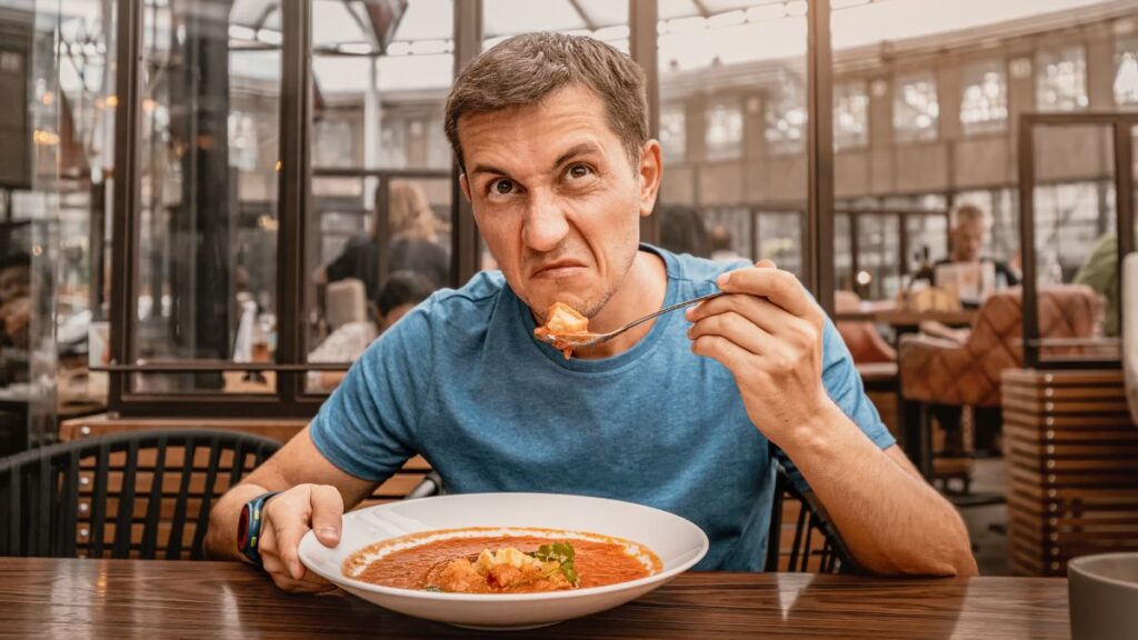 man with rude face eating out