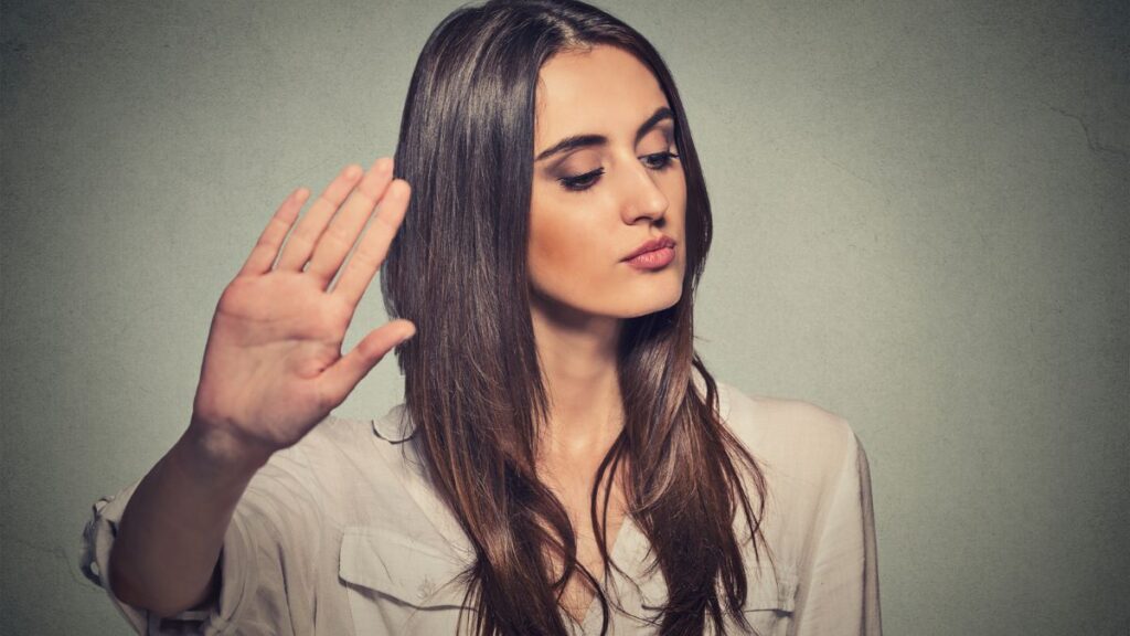 rude woman looking away with hand up