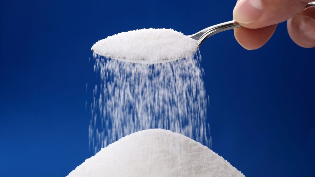 a spoon pouring sugar