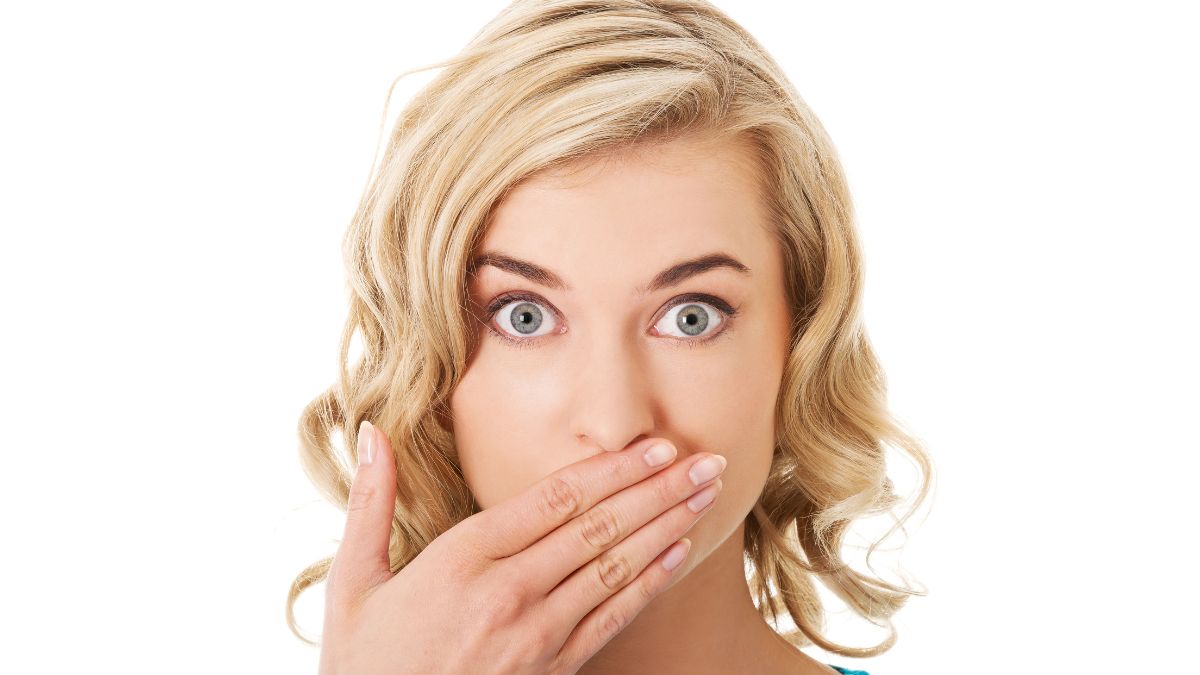 surprised blond woman with hand over mouth