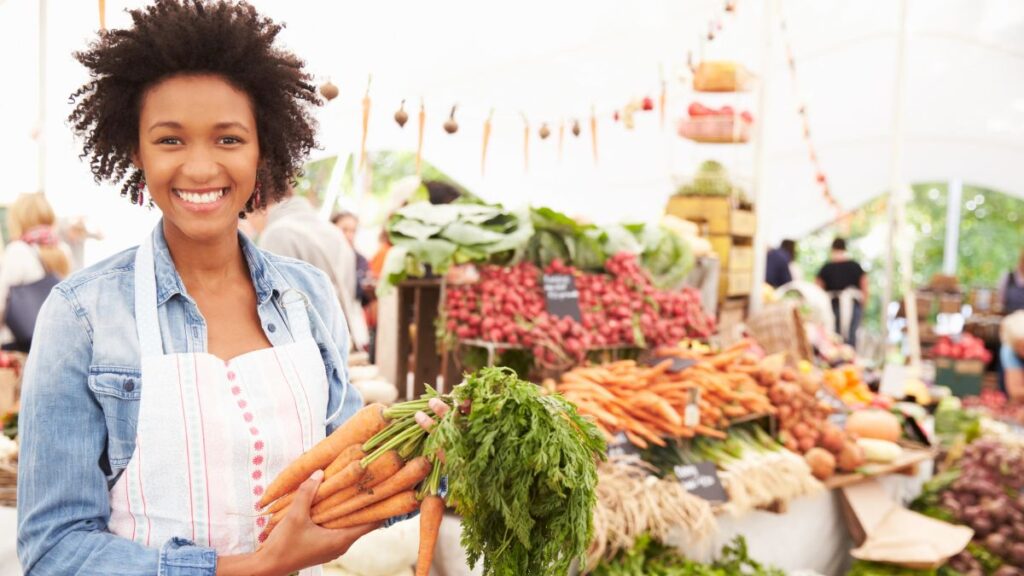 woman at food market with carrots