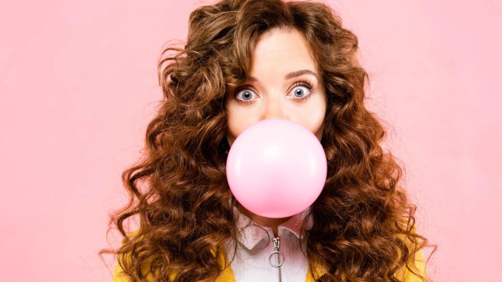 woman blowing a bubble with gum