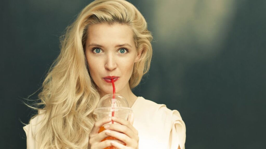 woman drinking juice from straw