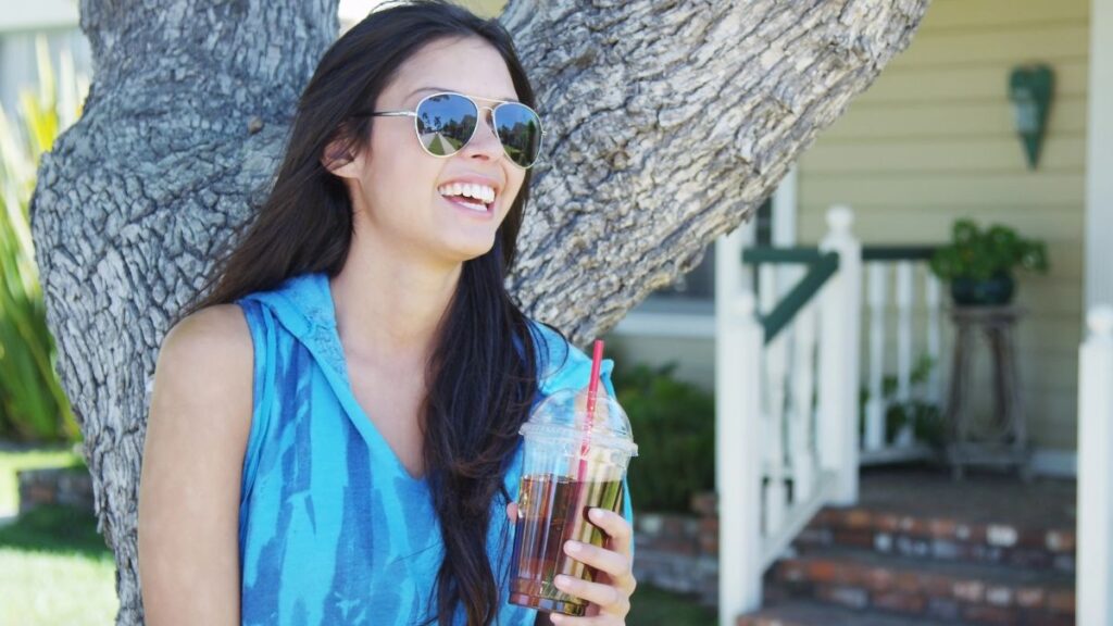 woman drinking soda outside