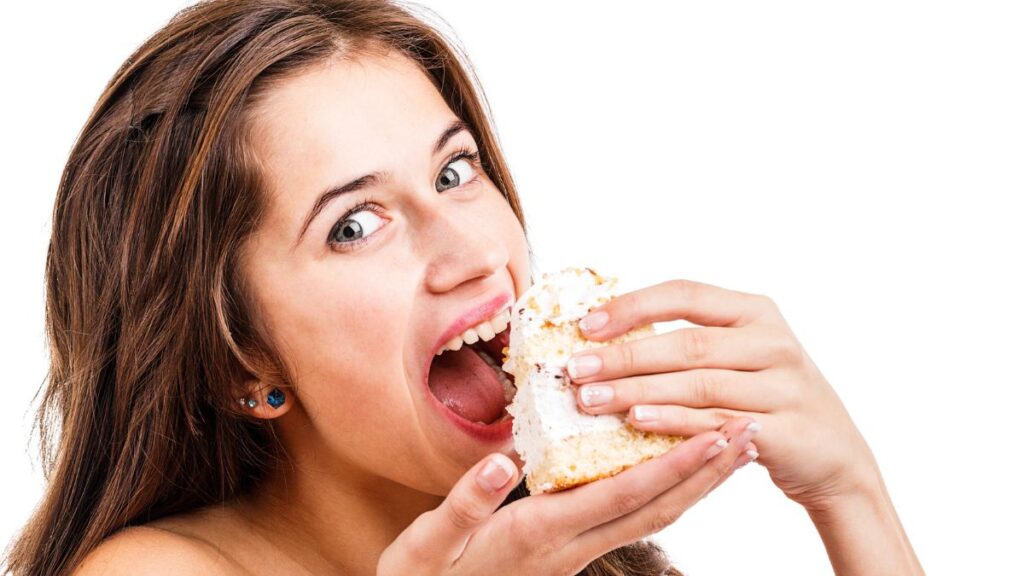 woman eating cake with her hands smiling