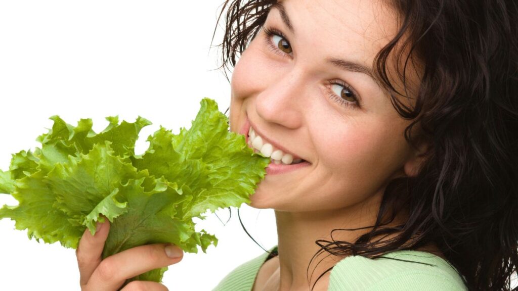 woman eating lettuce with hands