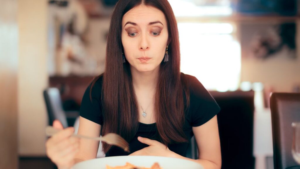 woman looking disgusted eating