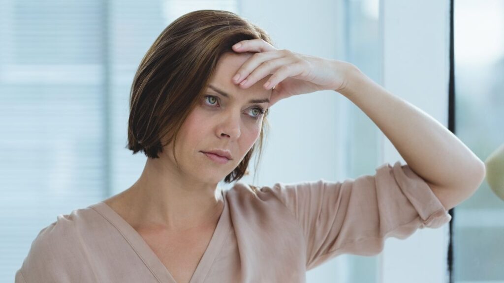 woman looking stressed with hand on head