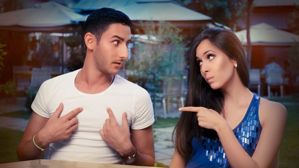 woman pointing at guilty looking man at table