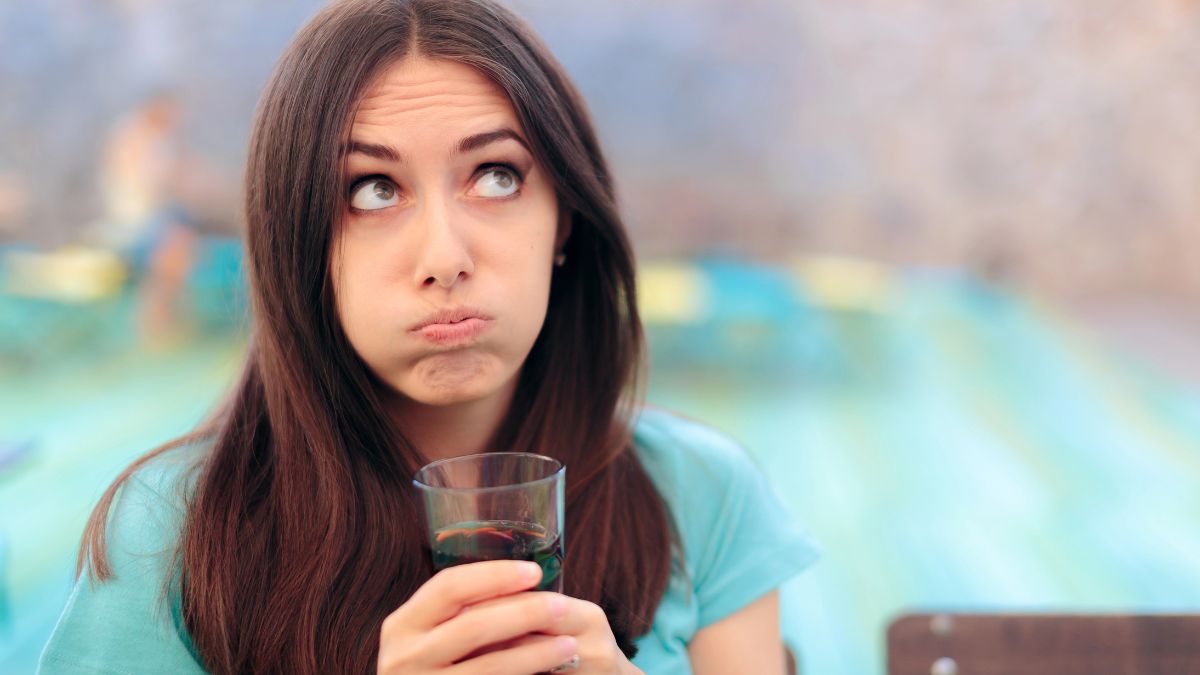 woman rolling eyes and holding a glass