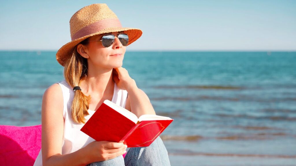 woman sitting and reading by the water