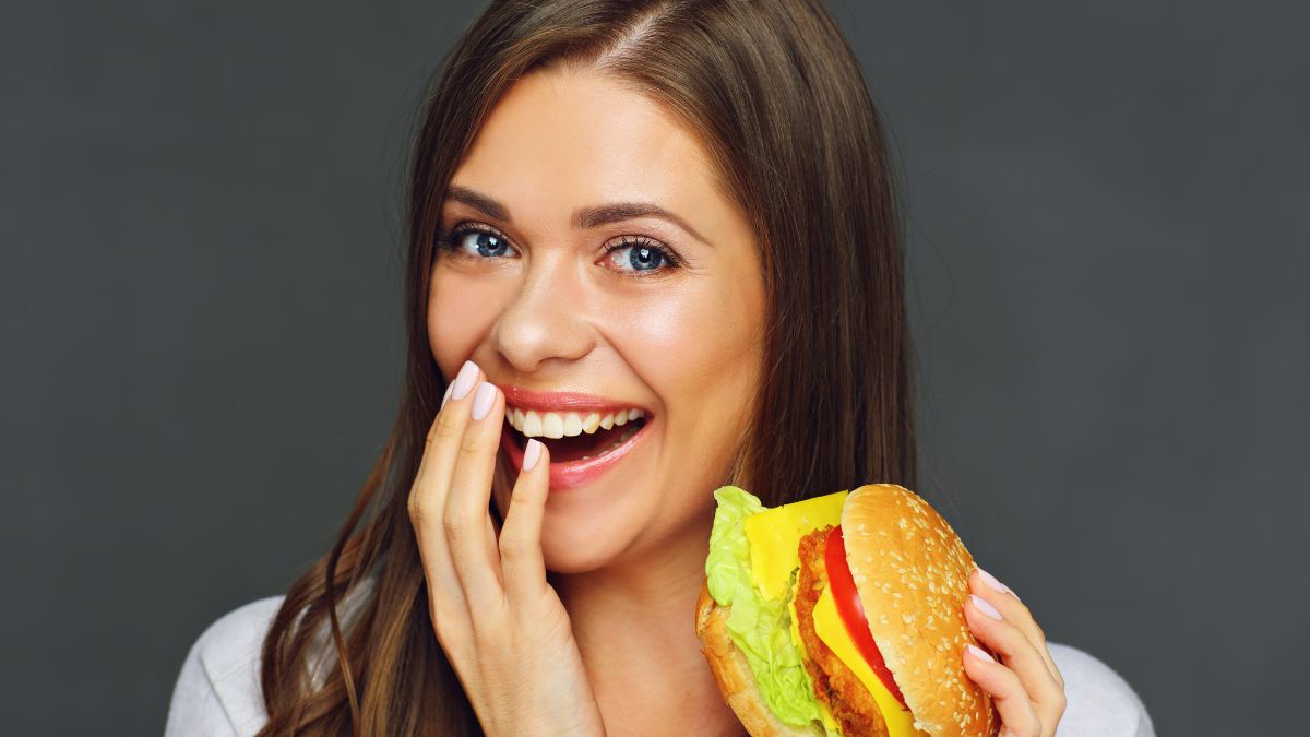 woman smiling with a cheeseburger