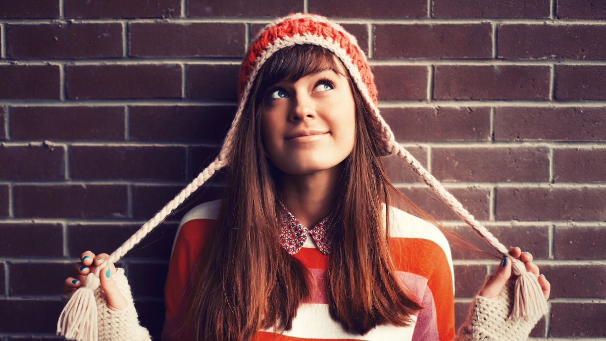 woman thinking holding hat strings