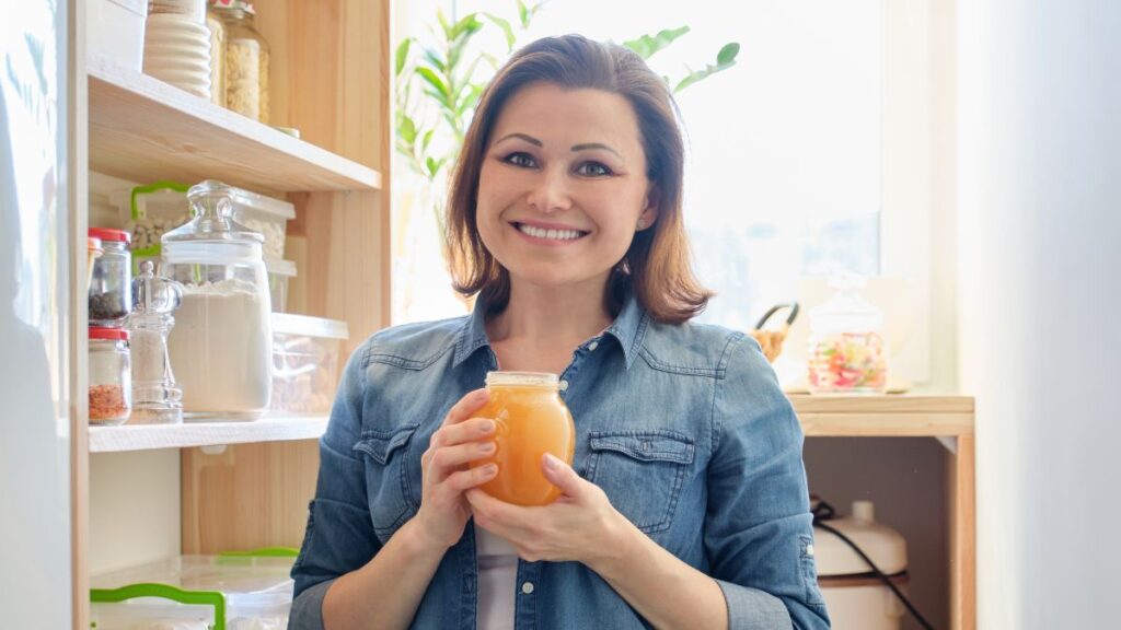 woman with honey smiling in pantry