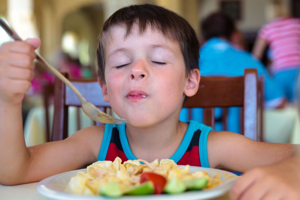 Boy enjoying food at the table.