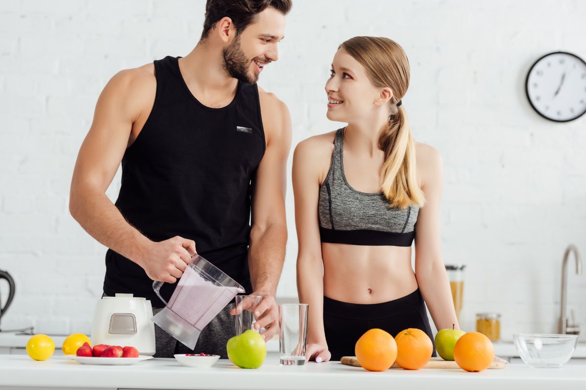 couple in the kitchen making a smoothie looking at each other