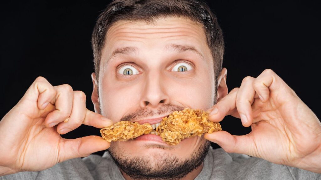 surprised man eating chicken