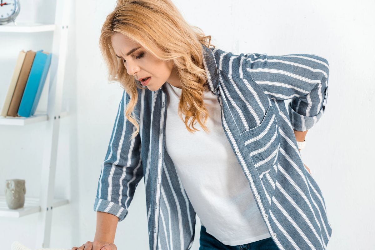 Woman with back pain in her living room.