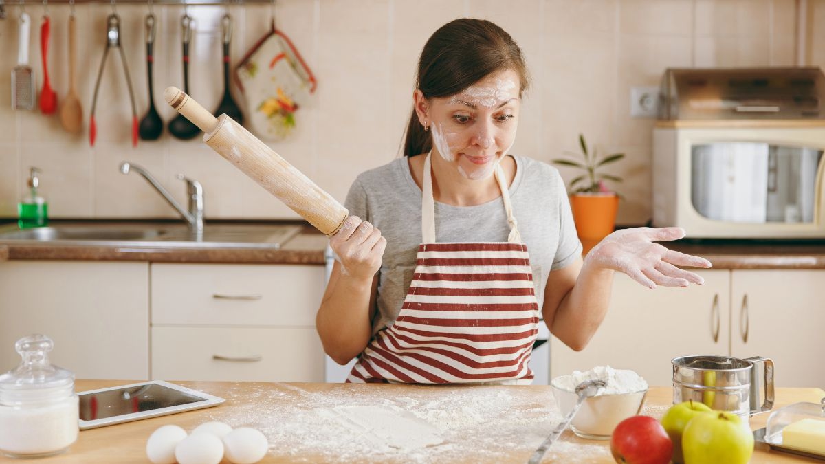 confused woman covered in flour in kitchen