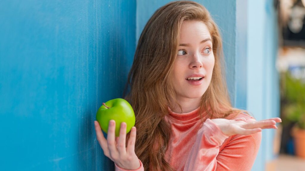 confused woman holding apple