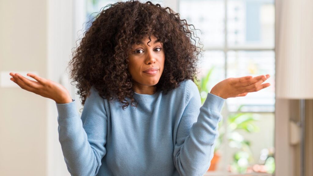 confused woman shrugging with hands up