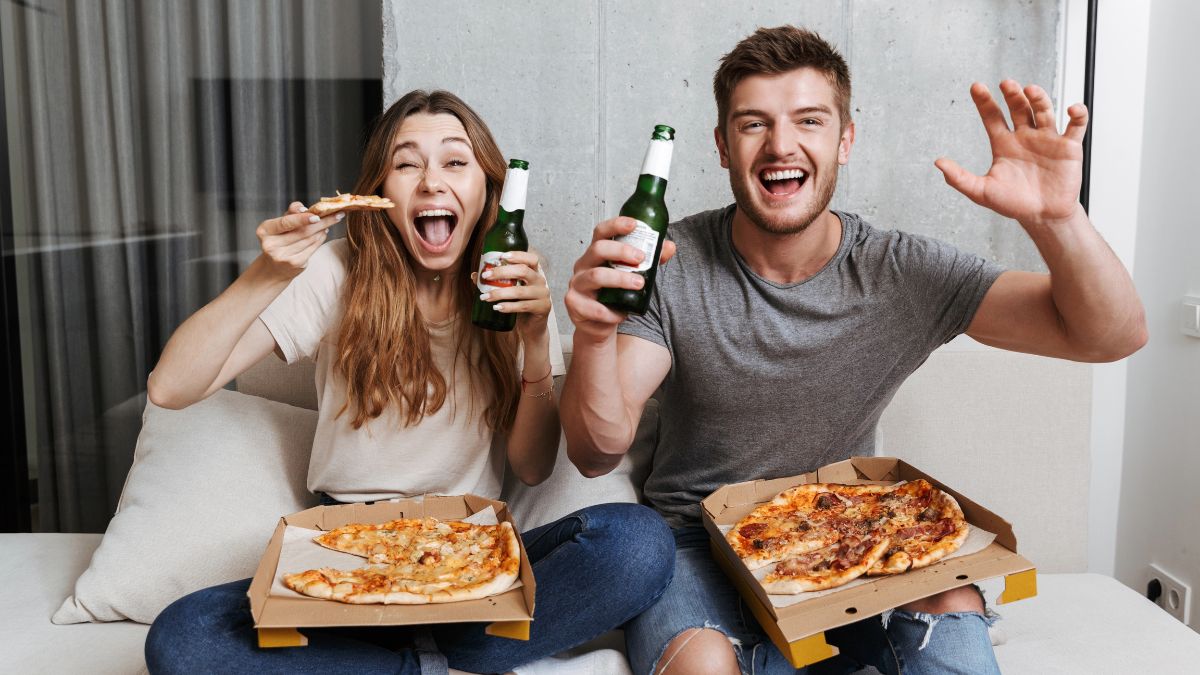 couple excited with pizza and beer