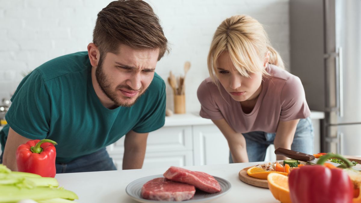 couple staring at meat looking confused