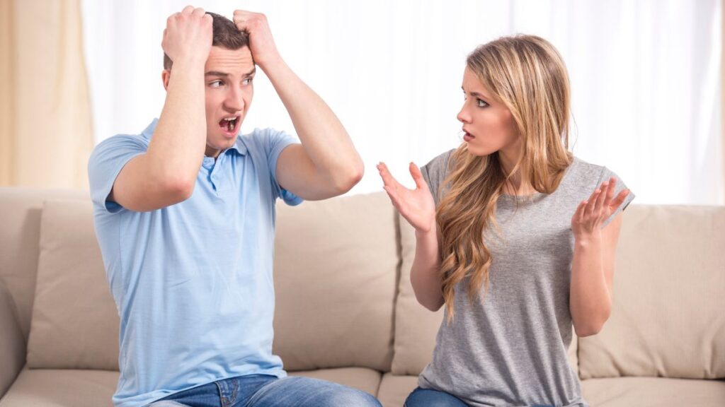 frustrated man confused woman couple sitting on couch