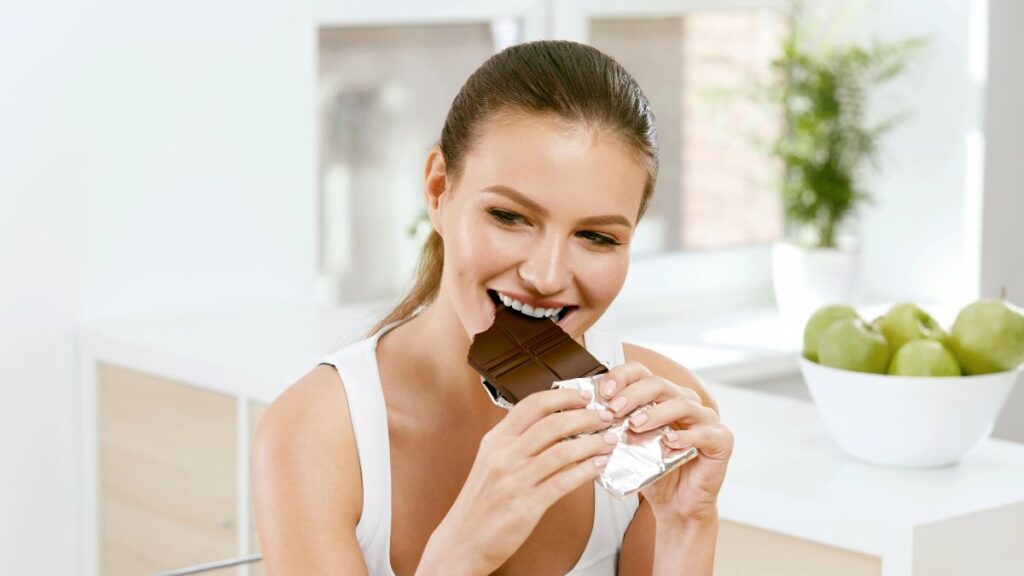 happy woman eating dark chocolate