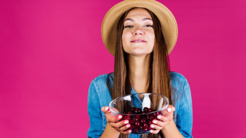 happy woman holding bowl of cherries