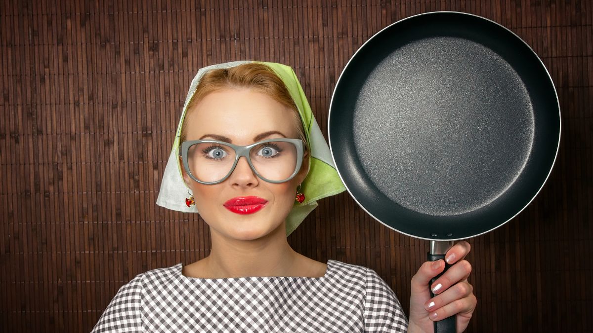 happy woman holding frying pan