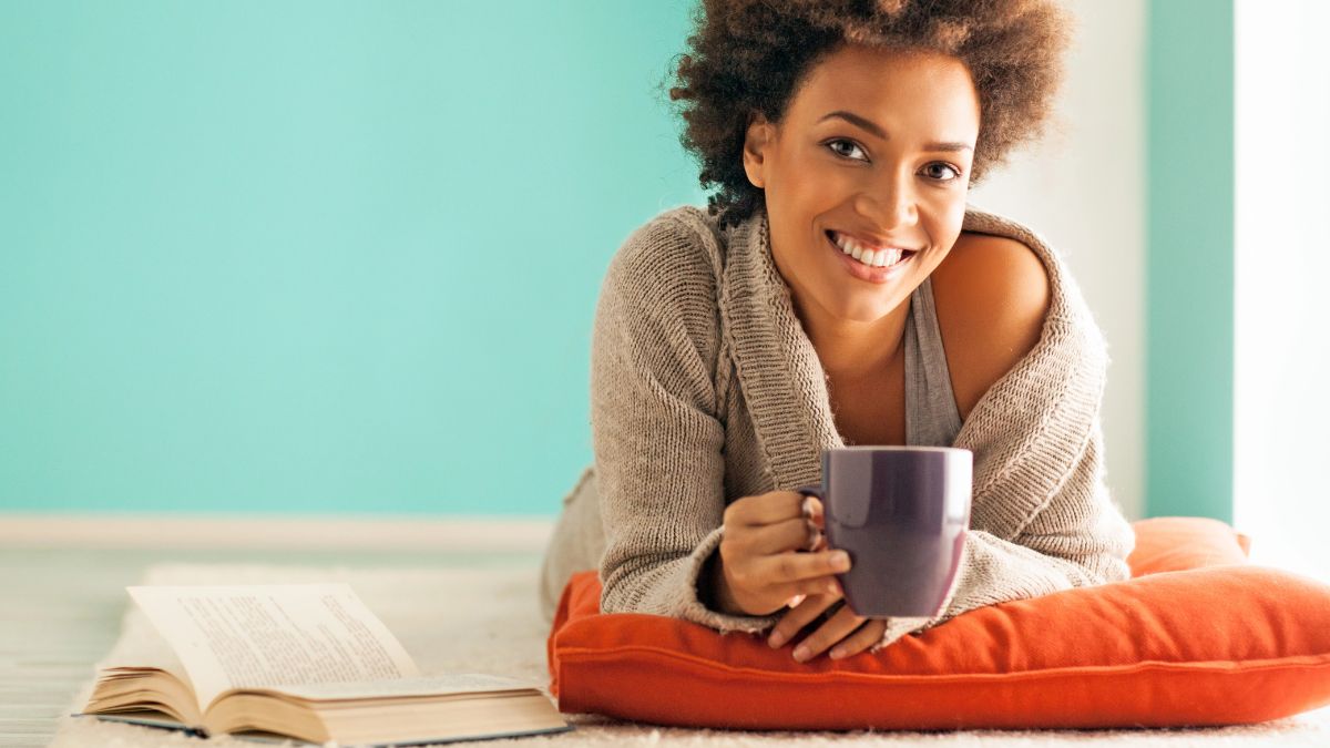 happy woman with coffee and book