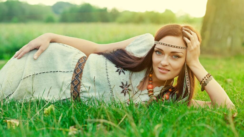 hippie woman laying in the grass smiling