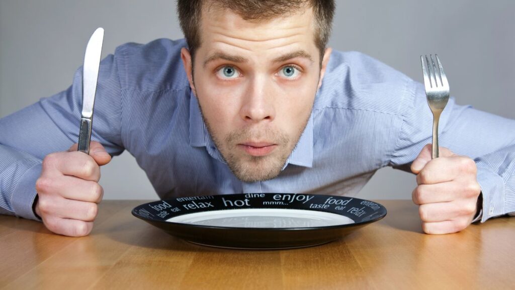 hungry man with plate fork and knife