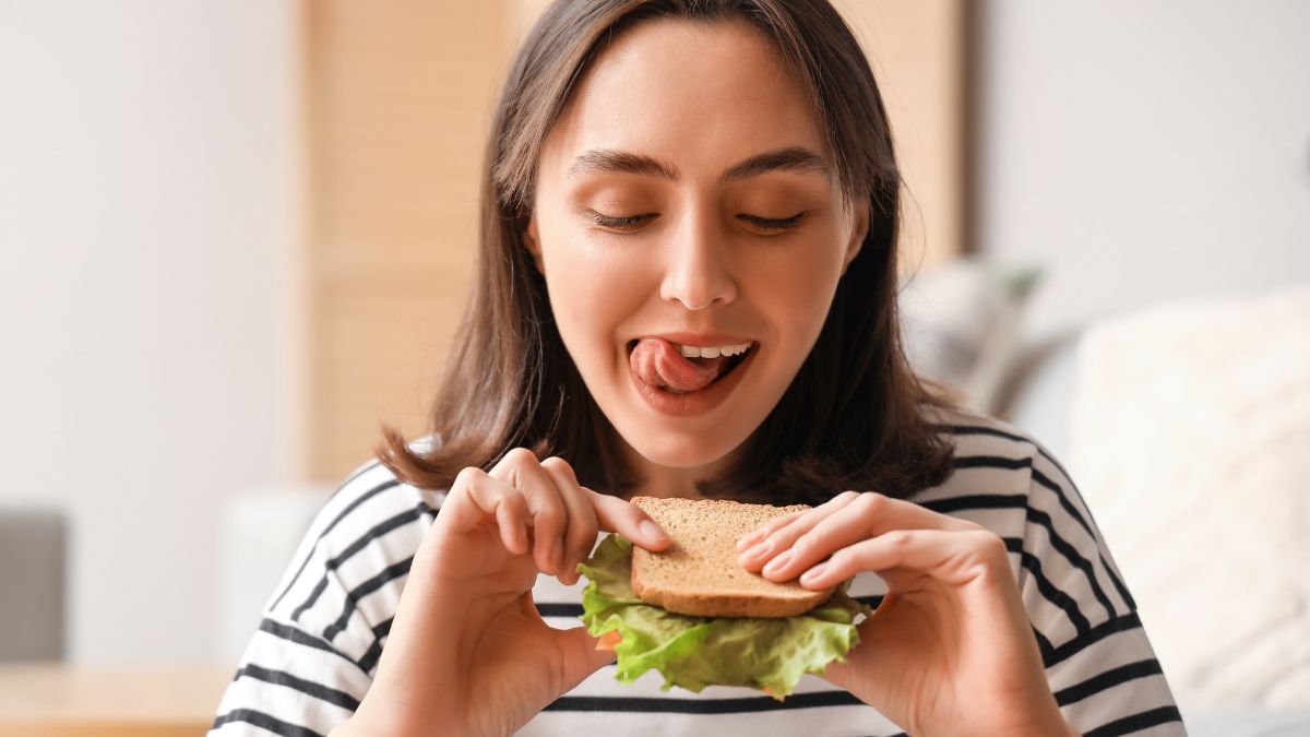 hungry woman eating sandwich