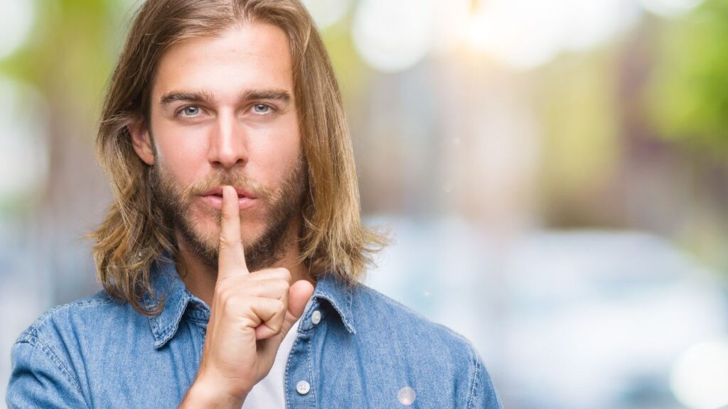 man showing shh with finger up