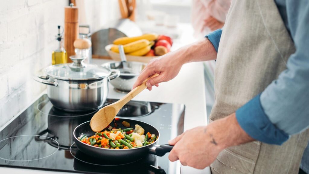 man cooking vegetables